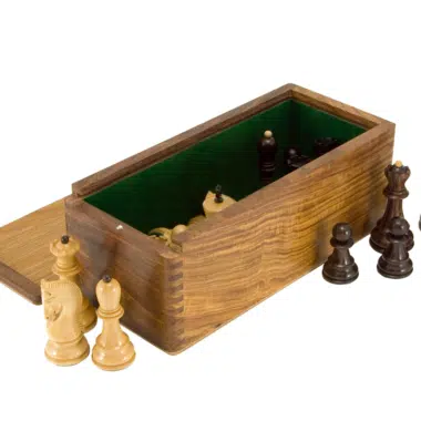Geöffnete Box mit hölzernen Schachfiguren daneben aufgestellt