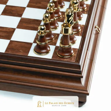 Ecke der massiven Holzplatte mit Aufbewahrungsschublade und aufgereihten goldfarbenen Figuren