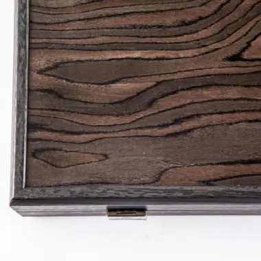 Detail der Kante der geschlossenen Box mit dezentem Verschluss und Furnieradern
