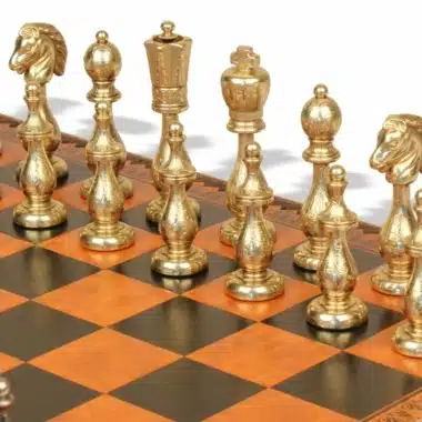 Detailansicht der goldenen Filigran-Metallfiguren aufgereiht auf den schwarzen und orangen Feldern