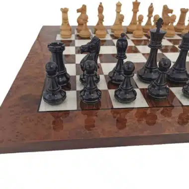 Schwarze Figuren im Vordergrund auf dem Schachbrett aus Nussbaumwurzel, Nahaufnahme
