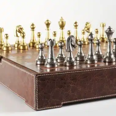 Gesamtansicht des kompletten Schachsets mit goldenen und silbernen Figuren auf Lederschachbrett