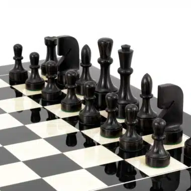 Dunkle Buchsbaum-Figuren aufgereiht auf dem schwarzen Ahorn-Schachbrett