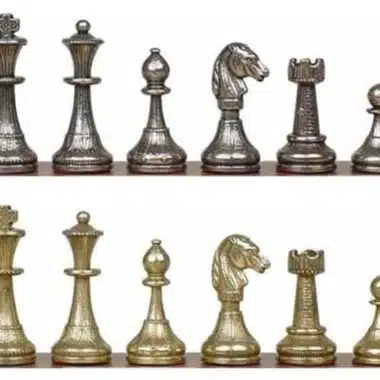Schachfiguren aus goldenem und silbernem Metall auf dem Schachbrett aufgereiht