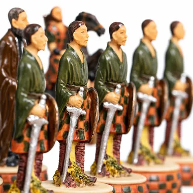 Schachfiguren in Reihe, schottische Krieger im Kilt mit Schwertern