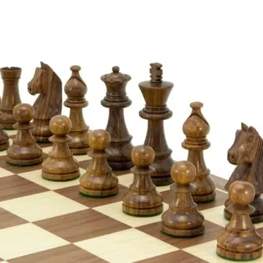 Dunkle Figuren aus goldenem Rosenholz aufgereiht auf dem Nussbaumbrett