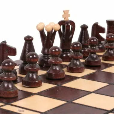 Dunkle Schachfiguren frontal aufgereiht auf dem Schachbrett