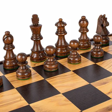 Dunkle Schachfiguren aus Holz auf dem Schachbrett aus Olivenholz