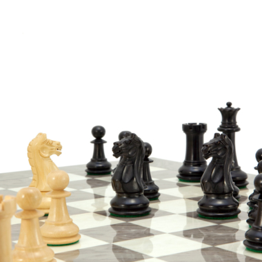 Dynamische Inszenierung des Oxford Ash Burl Schachspiels mit Staunton-Figuren in Aktion auf dem Brett